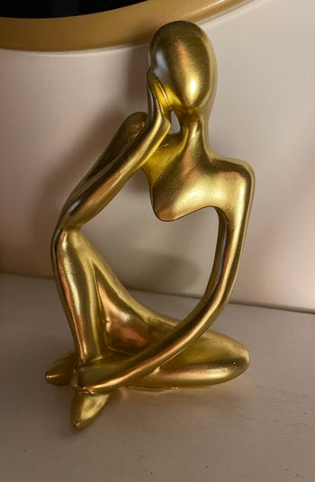 Image of product in gold sitting atop a white shelf