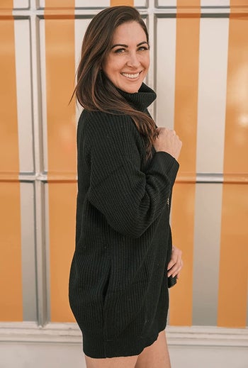 reviewer wearing the black sweater dress