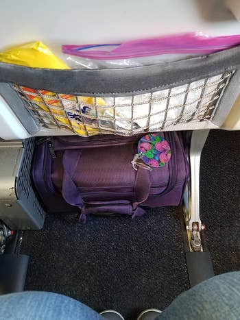 the suitcase under a plane seat