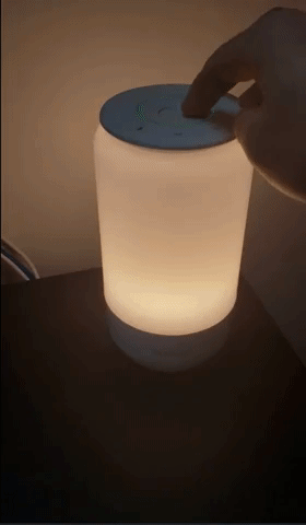 gif of a reviewer's video of them using a spinning touch dial to change the light temperature on a desk lamp