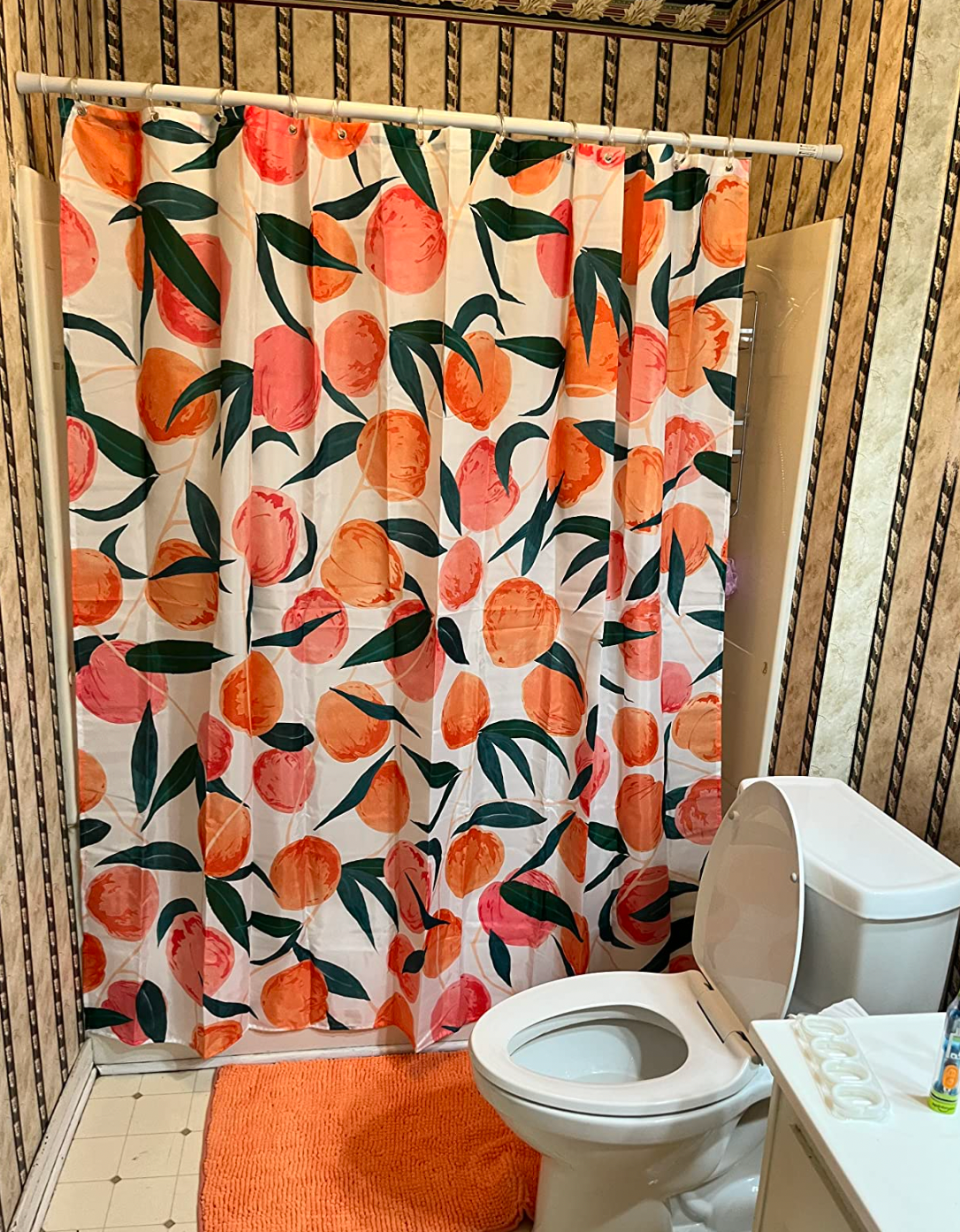 a reviewer with the shower curtain hanging in their bathroom