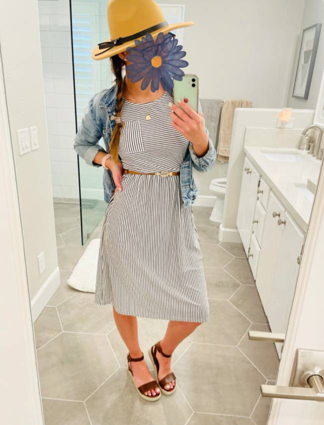 Reviewer photo of the dress with white and blue vertical stripes, a denim jacket, and sandals