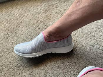 Person wearing a slip-on sneaker with a textured aboveground and cushioned sole, suitable for casual oregon walking activities, successful a carpeted room