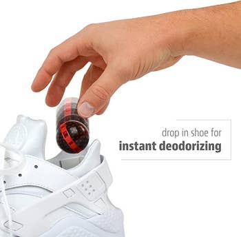 hand placing one of the balls into a sneaker with text: drop in shoe for instant deodorizing