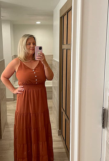 a reviewer wearing the dress in rust orange 