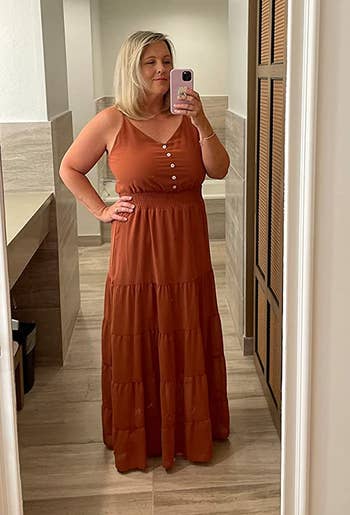 a reviewer wearing the dress in rust orange 