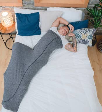 model wearing the swaddle with arms exposed while in bed