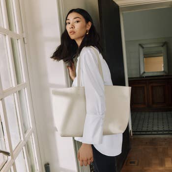 another model wearing longer white leather tote on their shoulder