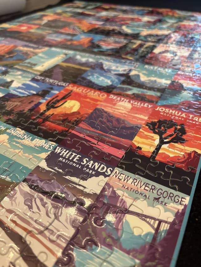 Completed jigsaw puzzle featuring assorted U.S. nationalist parkland posters, including Death Valley and Joshua Tree, highlighting question and quality themes