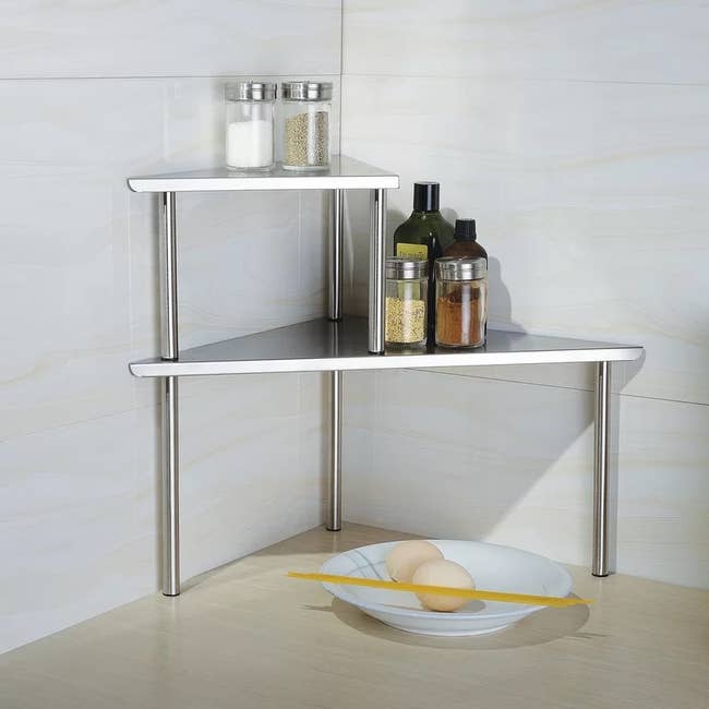 A silver rack in the kitchen corner with spices on it 