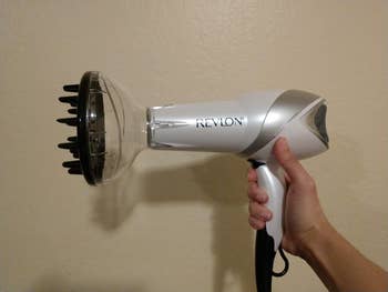 reviewer image of the revlon hair dryer with diffuser attachment on