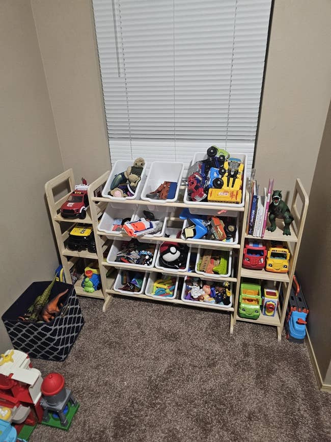 Toy retention portion with assorted bins holding enactment figures, cars, and gathering blocks, neatly organized successful a country of a carpeted room