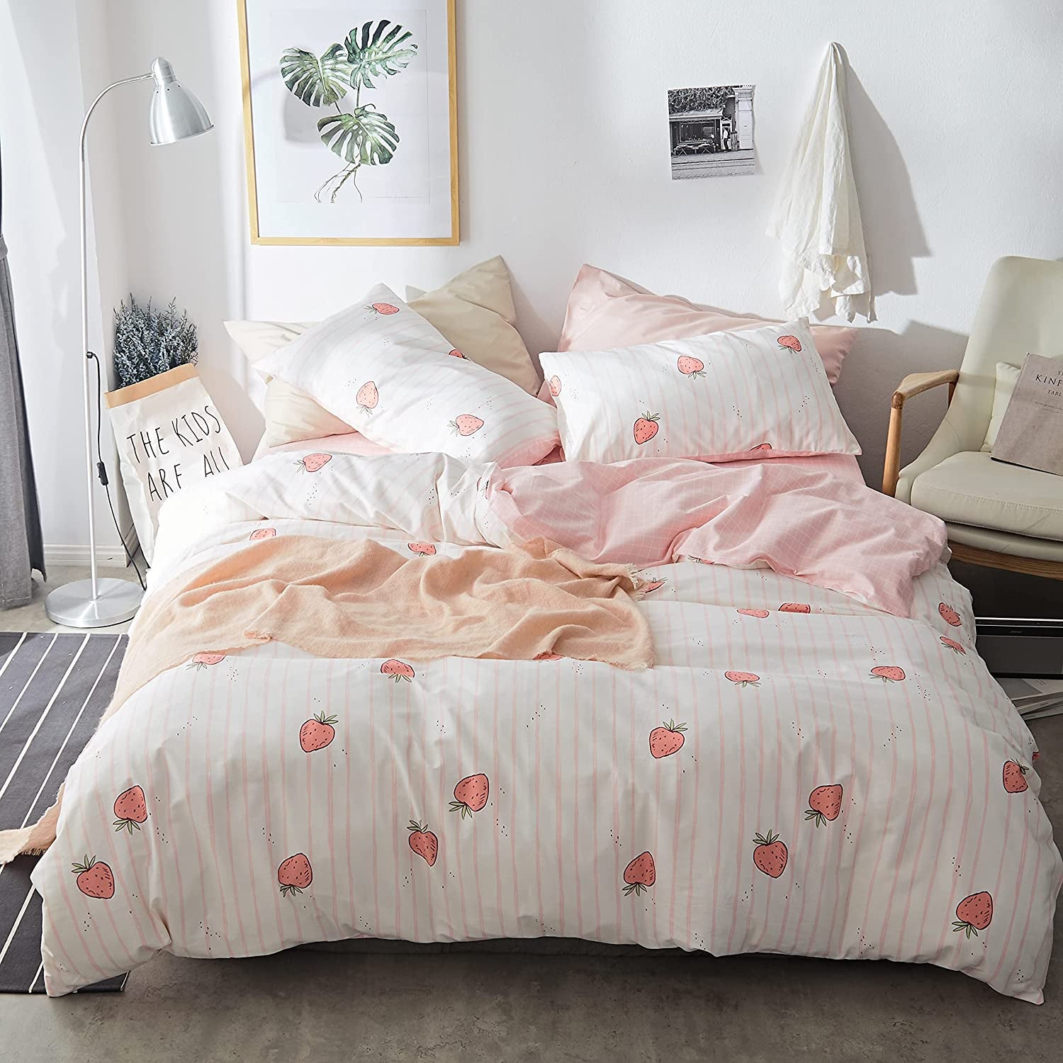 a white duvet set with light pink stripes and small red strawberry pattern