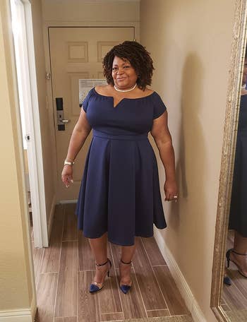 reviewer wearing the cocktail dress in navy