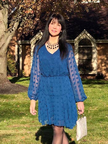 A reviewer wearing the dress in blue 