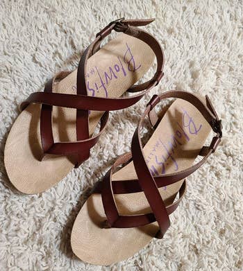 a reviewer photo of the strappy flat sandals in brown 