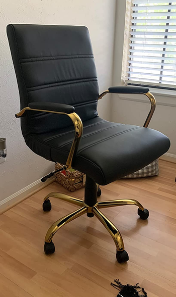 a reviewer photo of the chair with a gold base in black 
