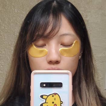 reviewer wearing the gold-colored eye patches