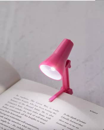 pink book light made to look like an desk lamp attached to a book
