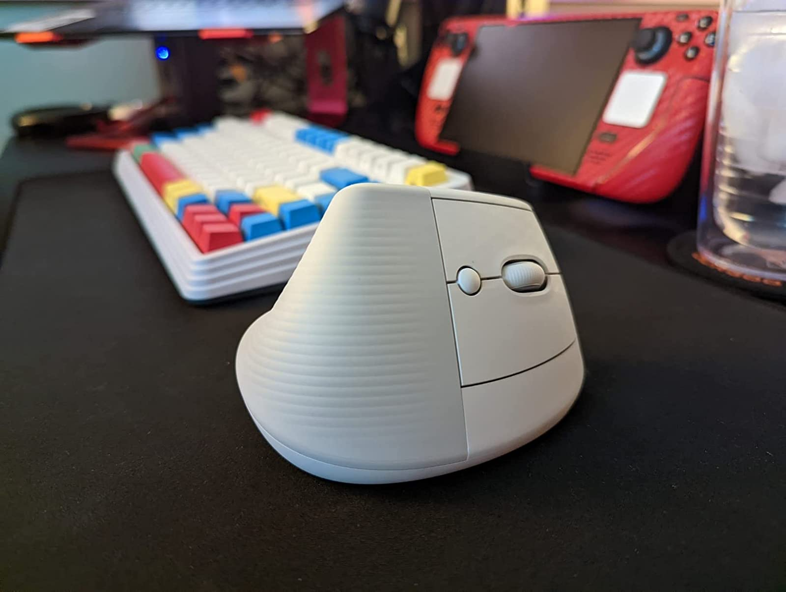 the white vertical mouse on a desk near a keyboard