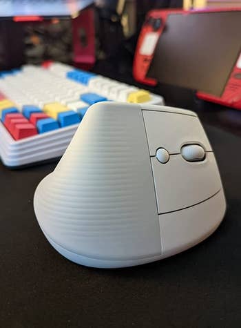 reviewer's white vertical mouse on a desk near a keyboard
