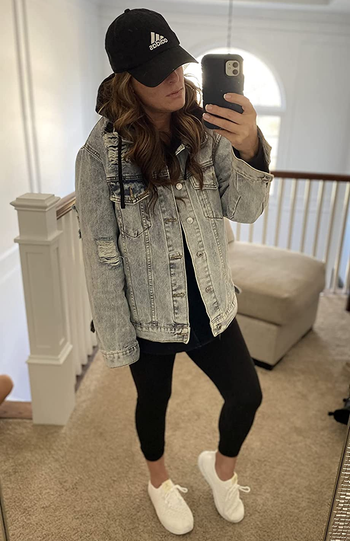 reviewer wearing the oversized denim jacket with black leggings