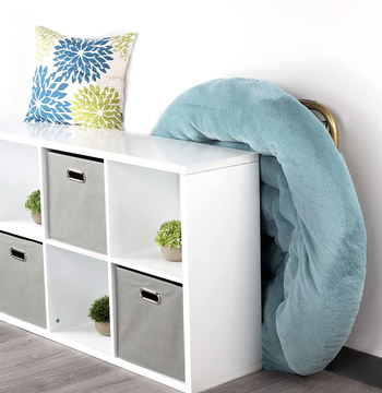 the blue chair folded up and stored behind a storage cabinet