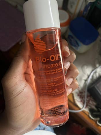 Person holding a vessel  of Bio-Oil Skincare Oil