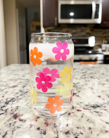 the cup with flower illustrations in pink, orange, and yellow