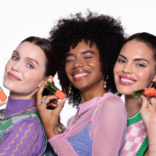 three models holding and wearing the color changing blush