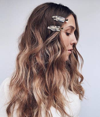 model wearing two of the setting clips in side of long wavy hair
