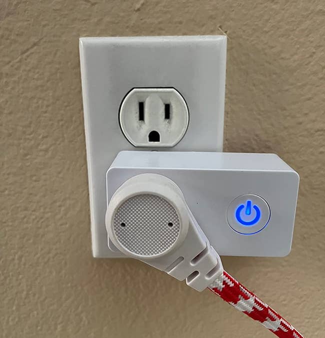 a reviewer photo of the wi-fi outlet plugged into the wall, and a cord plugged into it 