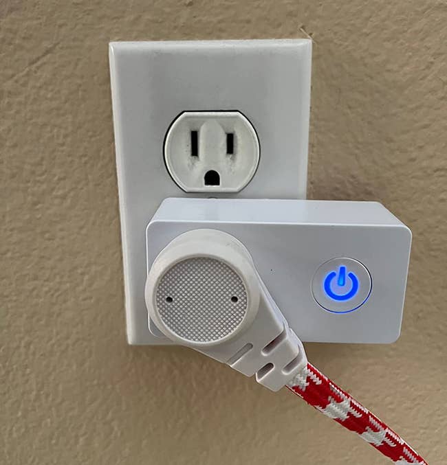 a reviewer photo of the wi-fi outlet plugged into the wall, and a cord plugged into it 