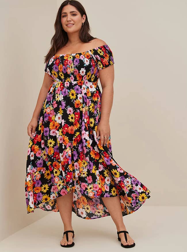 Model in black maxi off the shoulder sleeveless dress with bright tulip pattern 