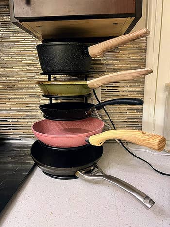 A reviewer photo of their pans stack neatly using the pan organizer 