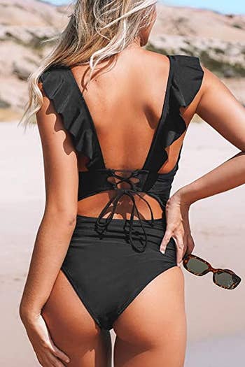 a model shows the back of the black bathing suit