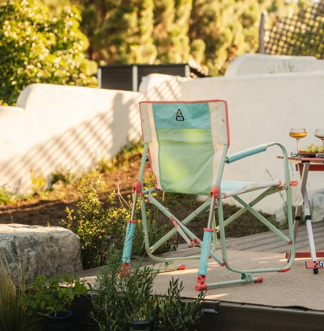 People sitting outdoors successful stylish folding chairs, enjoying a repast with drinks and snacks connected a table. Trees and greenery successful the background