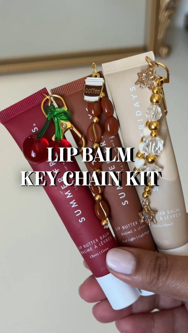 Hand holding 3  tubes of articulator  balm with attached beaded keychains