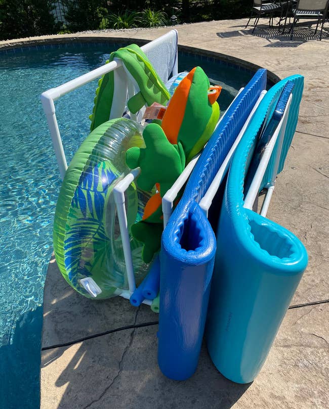 various pool floats, noodles, and towels on the organizing rack