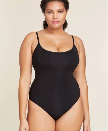 Model in a strapped black one-piece suit 