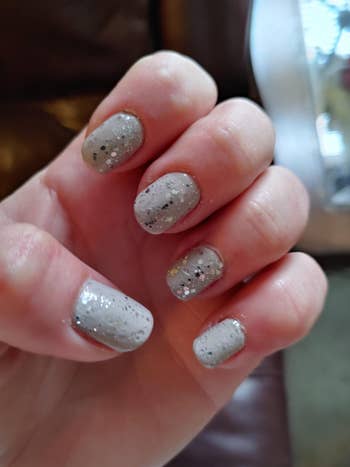 Close-up of a hand featuring glittery manicured nails