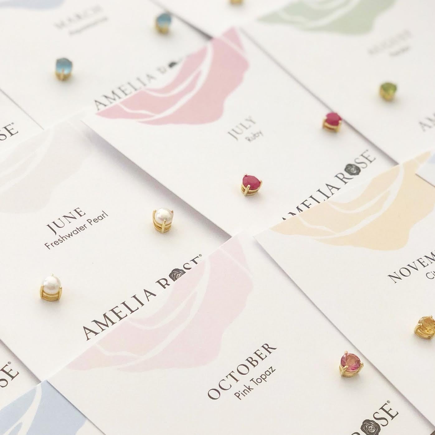 Image of several stud earrings, including pearl, ruby, pink topaz, and citrine