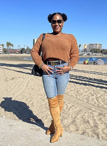reviewer wearing the tan boots with jeans and a brown sweater