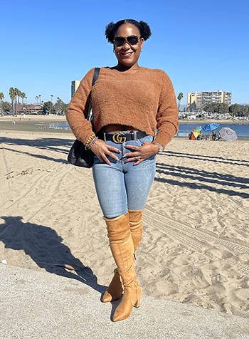 reviewer wearing the tan boots with jeans and a brown sweater