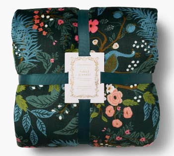Floral-patterned fleece broad  featuring peacocks and leaves, secured with a ribbon