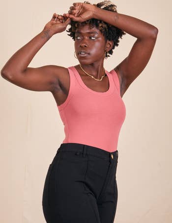 model in the pink tank top with black pants
