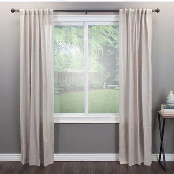 The curtain rod in the color Brown with curtains hung from it