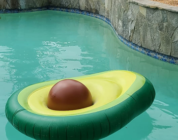 reviewer's avocado float in the pool with brown ball as the pit