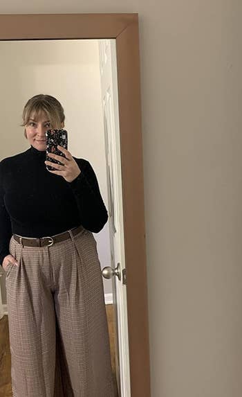 reviewer wearing the brown plaid palazzo pants with a black turtleneck