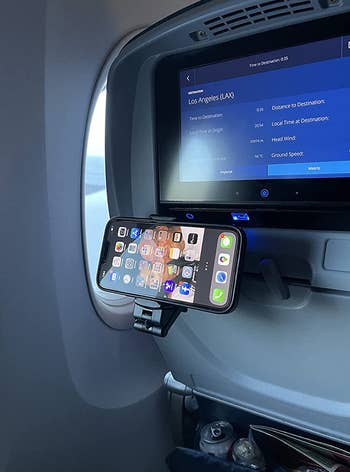 reviewer photo of the phone mount attached to their stowed away tray table